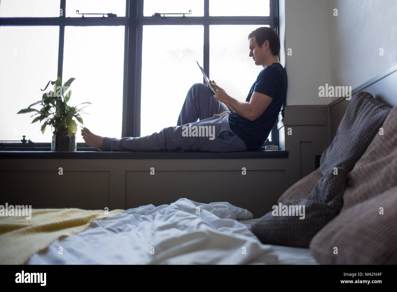 Jeune homme la lecture sur tablette numérique Banque D'Images