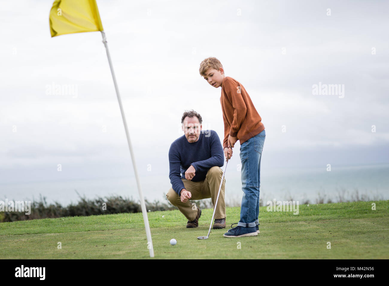 Père Fils regarder jouer au golf Banque D'Images