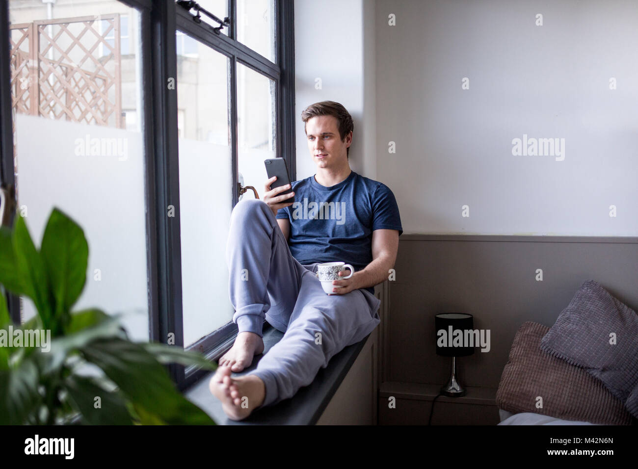 Jeune homme avec le smartphone et le café Banque D'Images