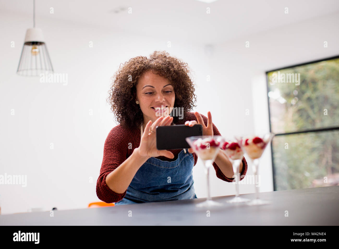 L'alimentation femelle blogger prend une photo avec le smartphone Banque D'Images