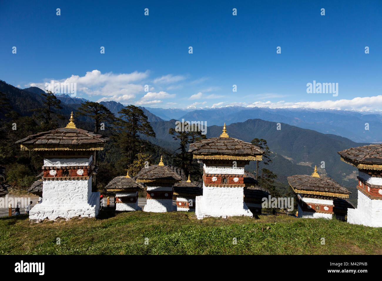 Punakha, Bhoutan. Chortens (sanctuaires) à un col dans les montagnes de l'Himalaya ; Contreforts de l'Himalaya dans la distance. Banque D'Images