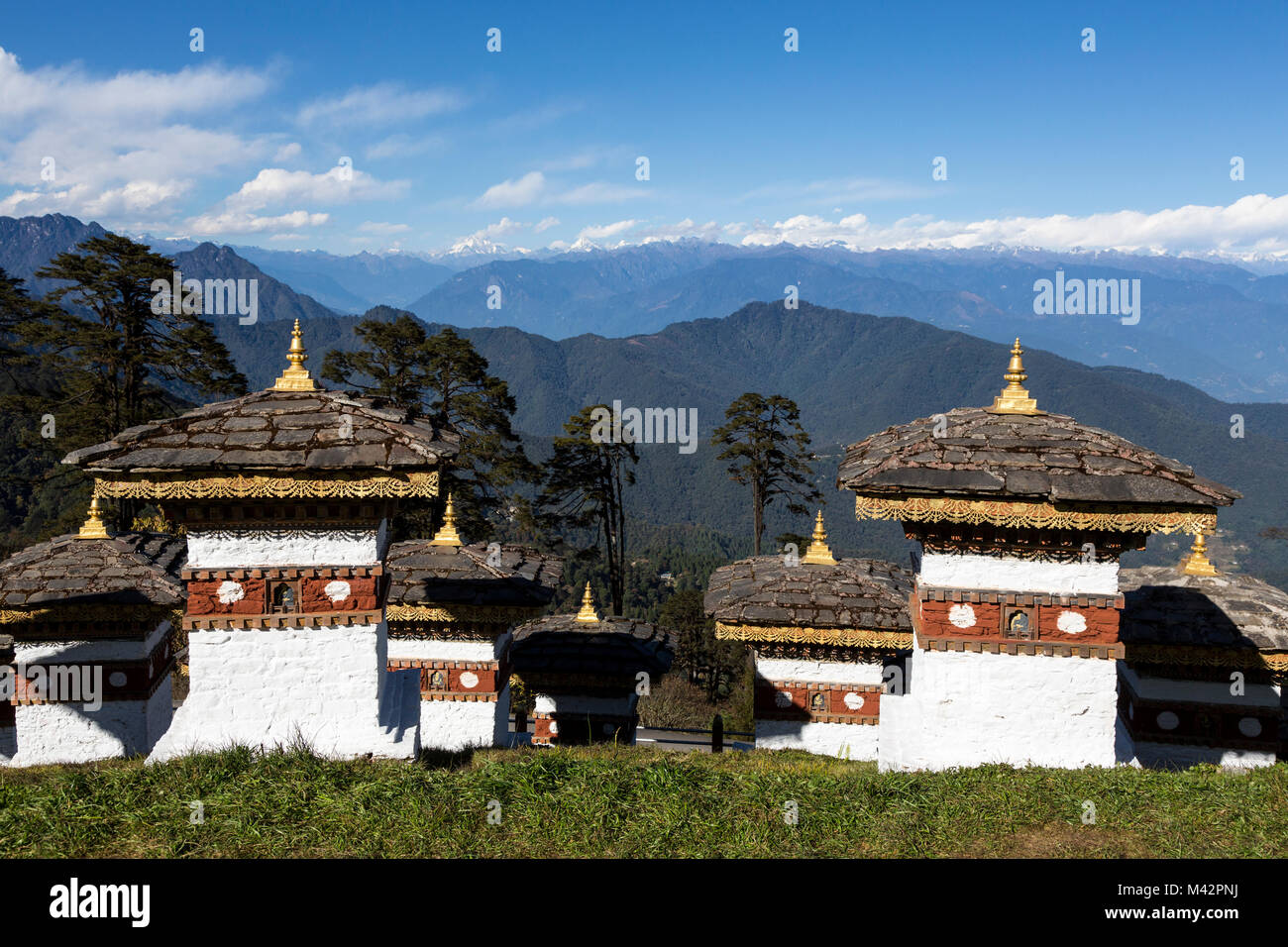 Punakha, Bhoutan. Chortens (sanctuaires) à un col dans les montagnes de l'Himalaya ; Contreforts de l'Himalaya dans la distance. Banque D'Images