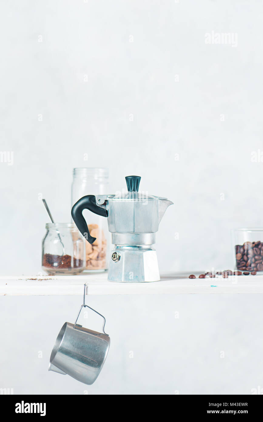 Touche haut verre photographie avec geyser italienne cafetière sur une étagère avec des ingrédients préparation du café et la verrerie. La photographie créative avec c Banque D'Images