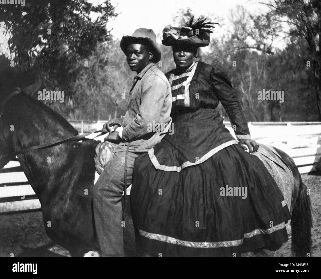 Photo personnelle d'une mère afro-américaine et fils adolescent au sommet d'un cheval à une plantation de coton dans le sud américain, ca. 1910. Banque D'Images