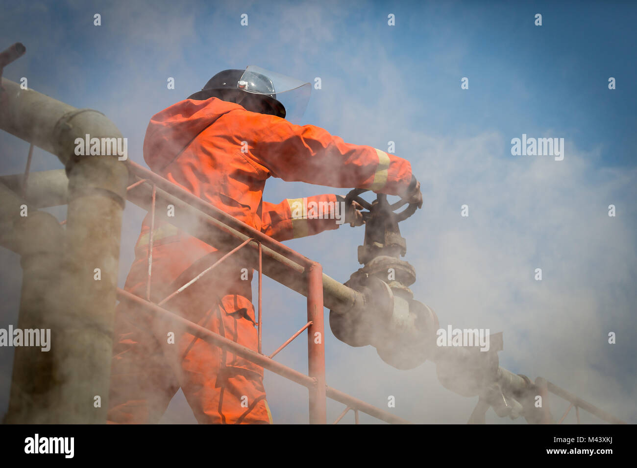 La formation, la pratique de l'équipe Firemans à lutter avec le feu en situation d'urgence. Fighter essayez de fermer la valve à gaz Banque D'Images