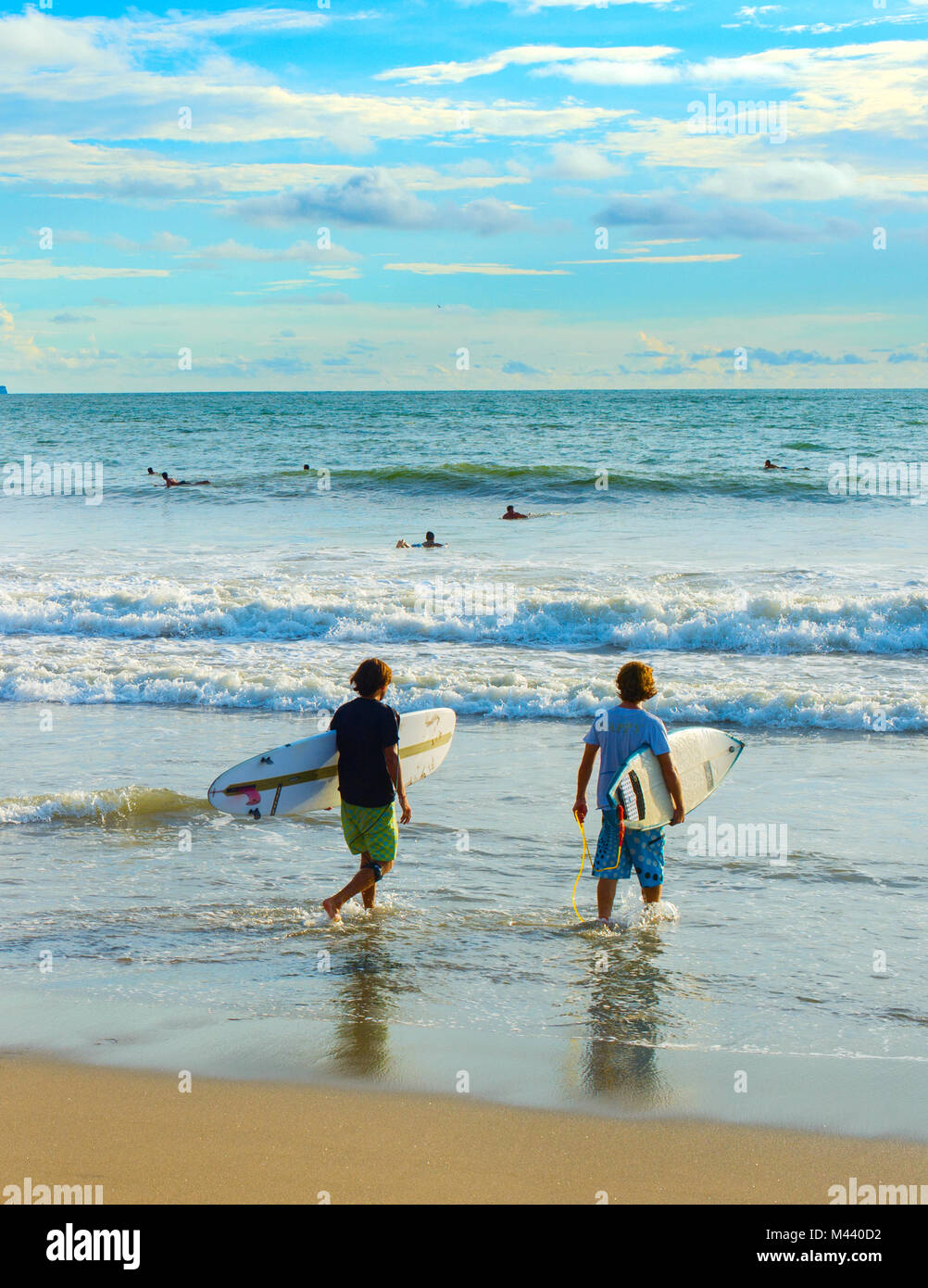 CANGGU, BALI, INDONÉSIE - Jan 19, 2017 : Deux de surfers passe à surfer sur la plage. L'île de Bali est l'une des meilleures au monde destinations surf Banque D'Images