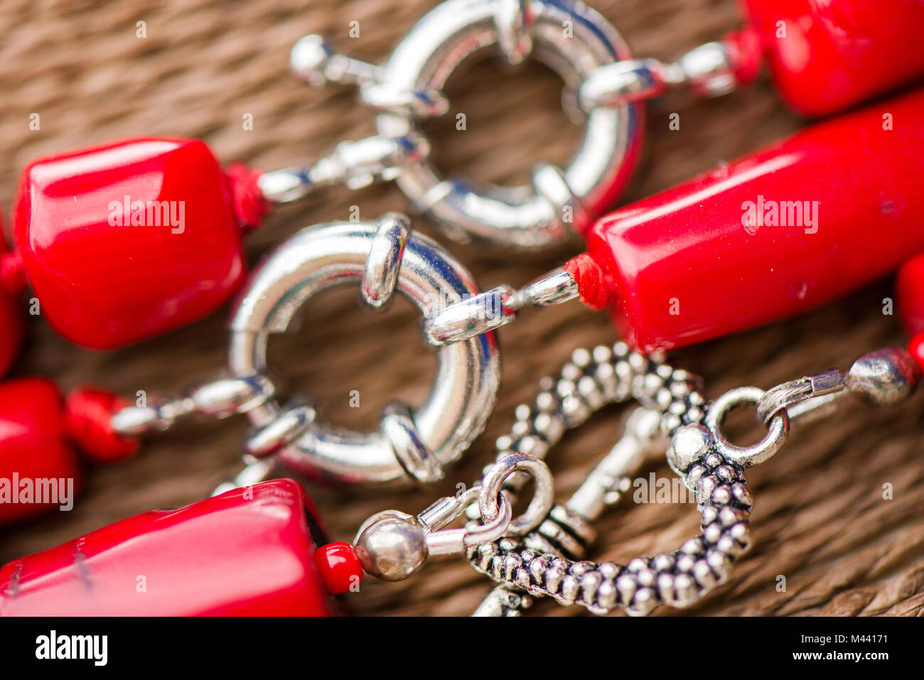 Agrafe d'argent sur une pierre de corail rouge et cristal collier. Belles pierres polies, sur fond rustique naturel, la guérison, l'énergie puissante de cryst Banque D'Images