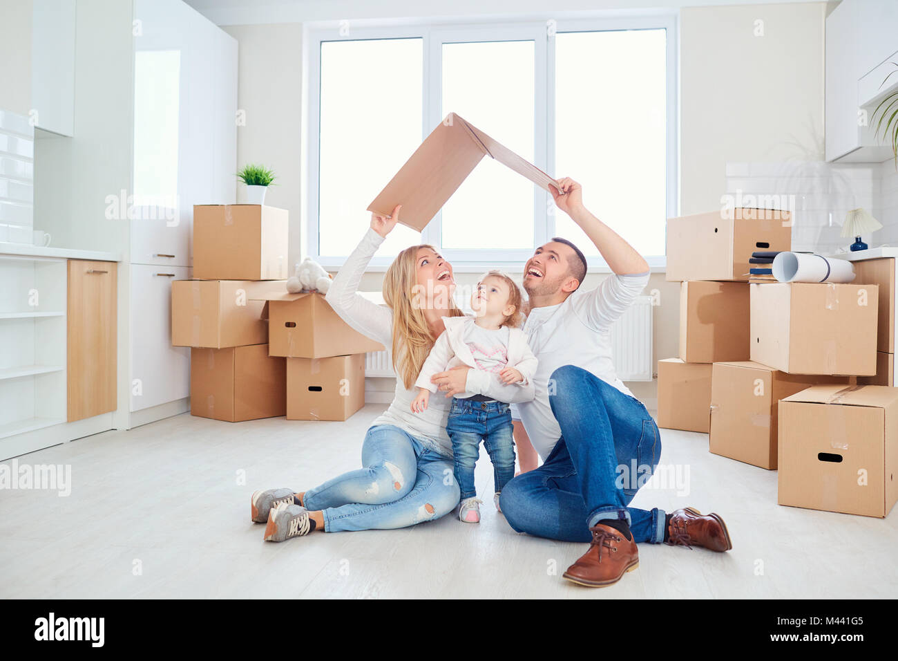 Une famille heureuse se déplace vers un nouvel appartement. Banque D'Images