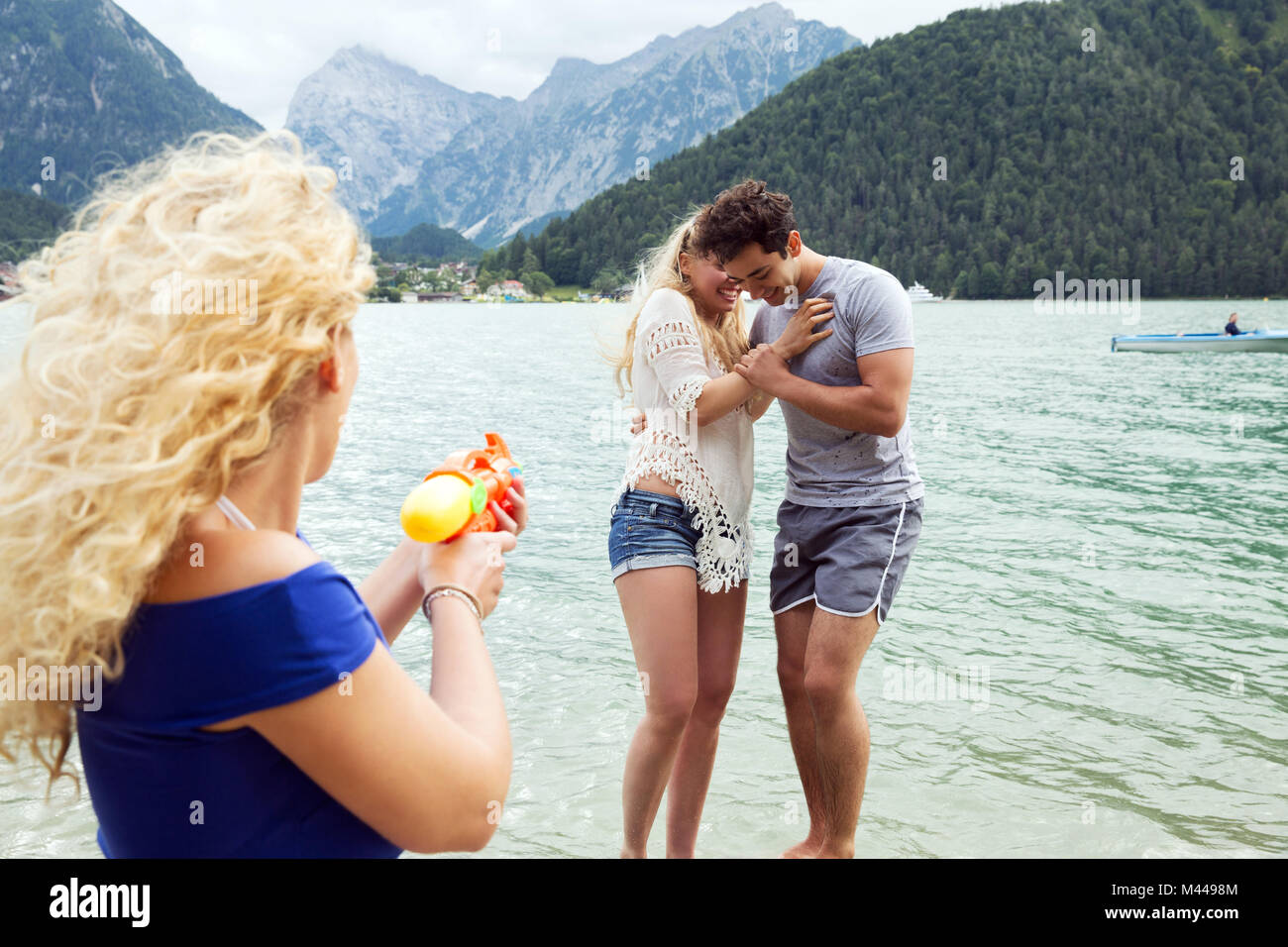 Woman squirting pistolet à eau à amis, Innsbruck, Tyrol, Autriche, Europe Banque D'Images