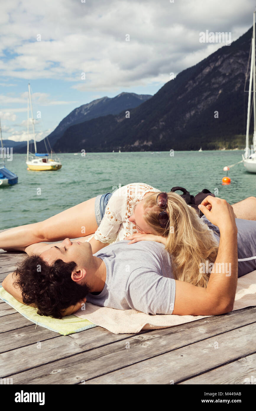 Couple lying together on pier, Innsbruck, Tyrol, Autriche, Europe Banque D'Images