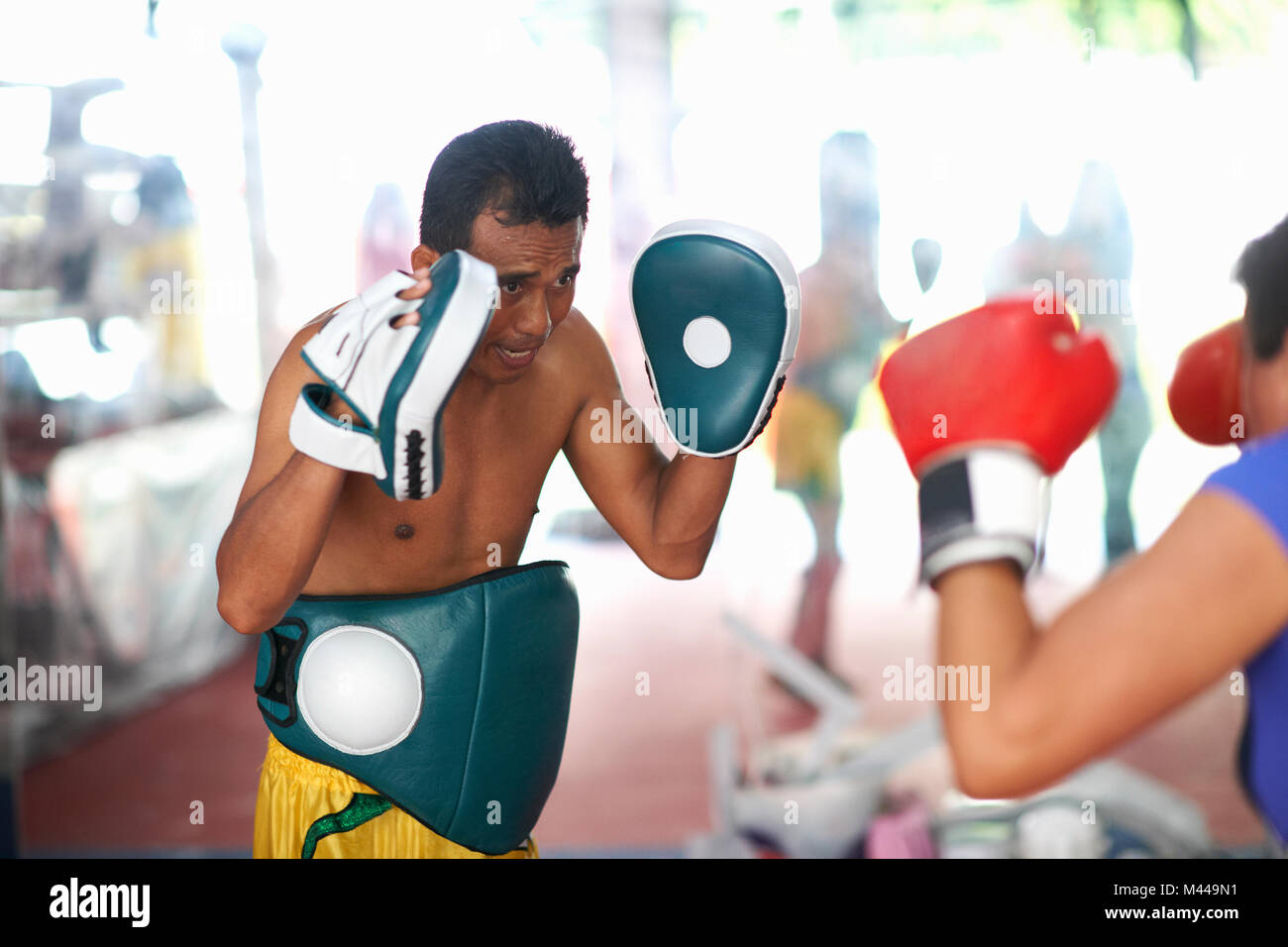 Young woman laying on boxe avec male trainer in gym Banque D'Images