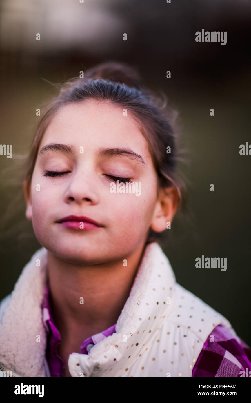 Portrait de jeune fille, à l'extérieur, les yeux fermés, l'air pensif Banque D'Images