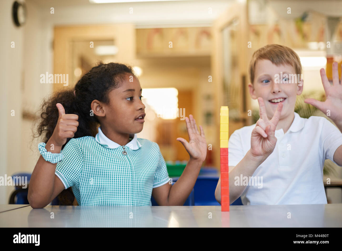 Écolier et compte sur les doigts en classe à l'école primaire Banque D'Images