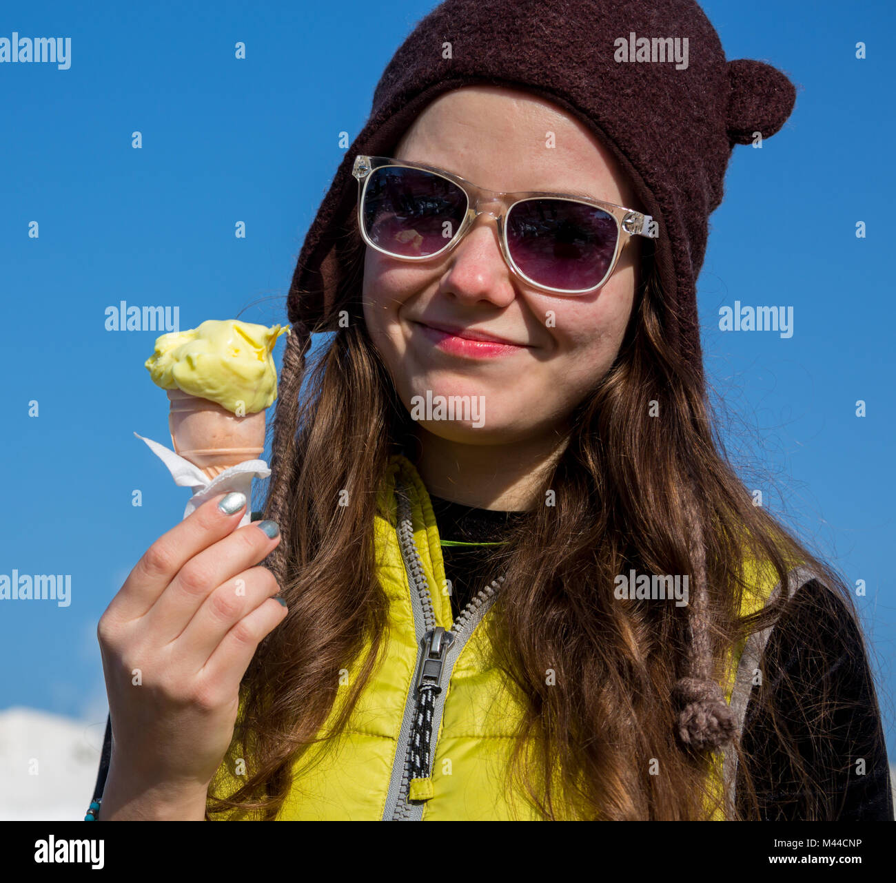 Gros plan extérieur fashion portrait of young girl crazy hipster la consommation de crème glacée en été quand il fait chaud en miroir rond lunettes de avoir l'amusement et la bonne humeur. Style tons filtres instagram Banque D'Images