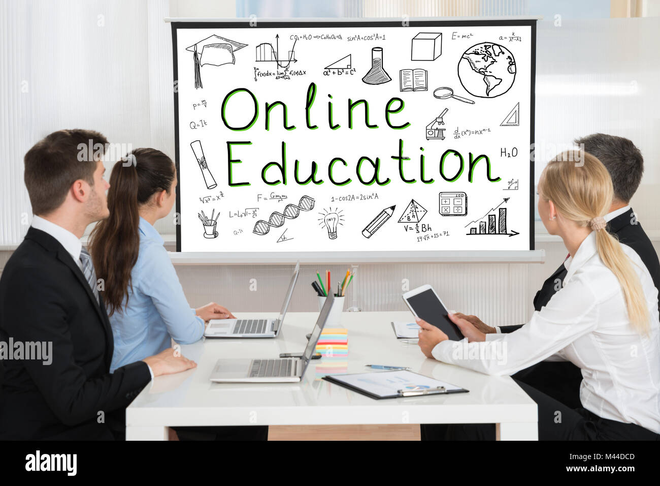 Close-up of Businesspeople Looking At Online Education Présentation avec des éléments de conception à bord Banque D'Images