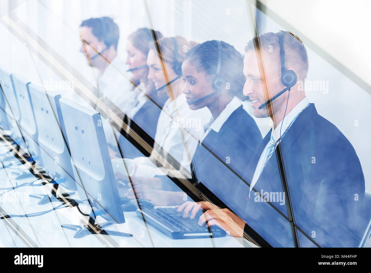 Hommes et femmes travaillant à des représentants du service à la clientèle 24 vu à travers le verre Banque D'Images