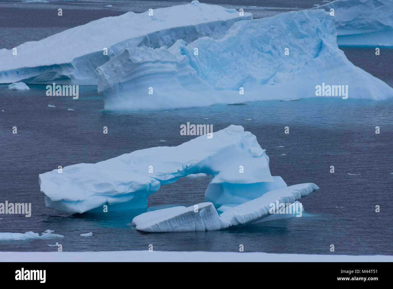 Un bleu turquoise, iceberg dans la baie de Charlotte, l'Antarctique flottant dans l'eau gris bleu de l'océan Austral. Banque D'Images
