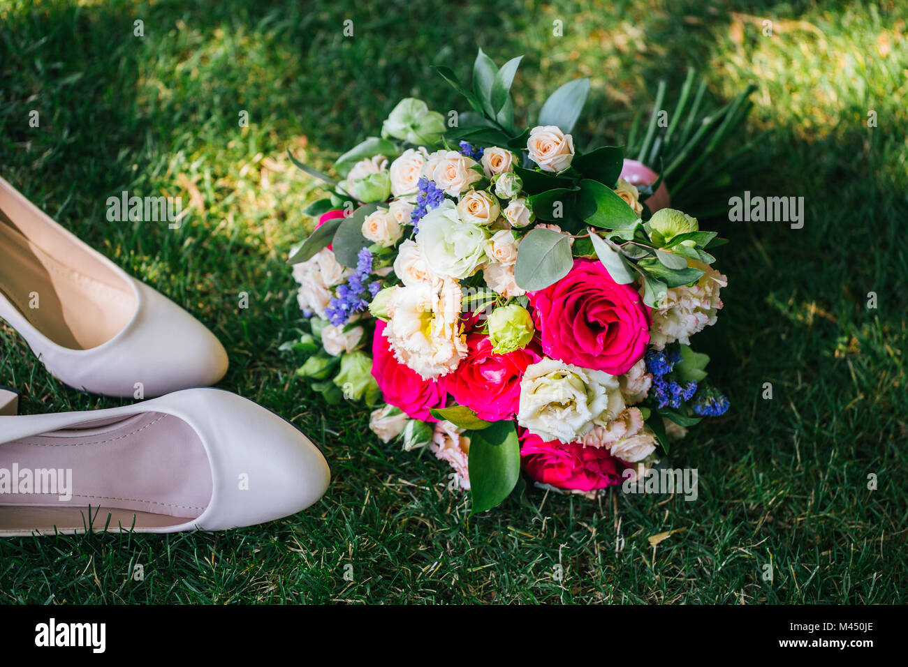 Chaussures avec bouquet allongé à côté de l'herbe Banque D'Images