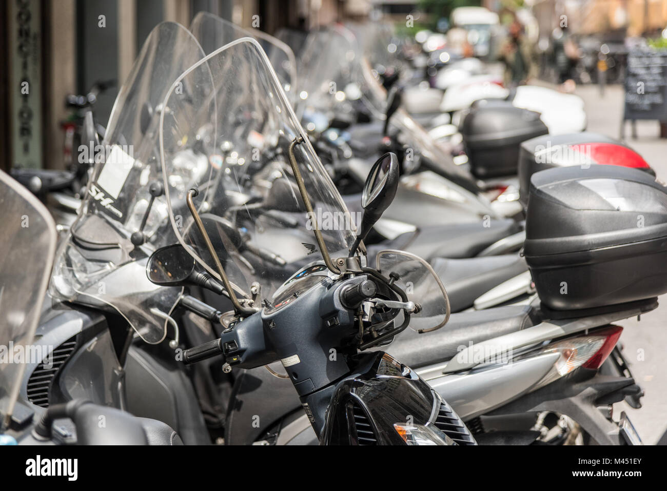 Rangées de motos et scooters en stationnement dans une rue de la ville de Bologne, Italie Banque D'Images
