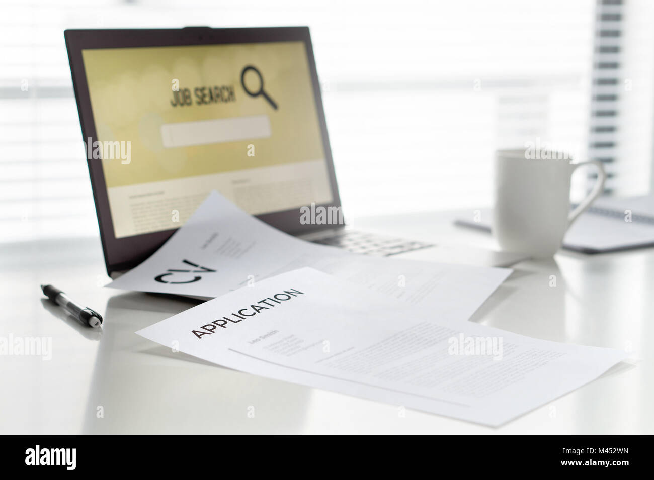 La recherche d'emploi dans la région de home office. Ordinateur portable avec moteur de recherche en ligne pour le travail. Curriculum vitae ou CV et l'application sur la table. Banque D'Images