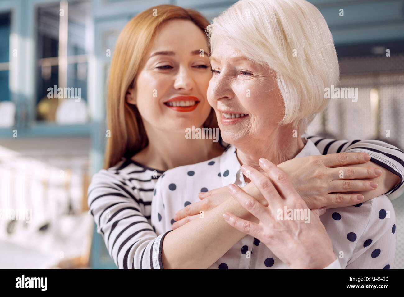 Close up d'aimer fille-étreindre sa mère âgée Banque D'Images