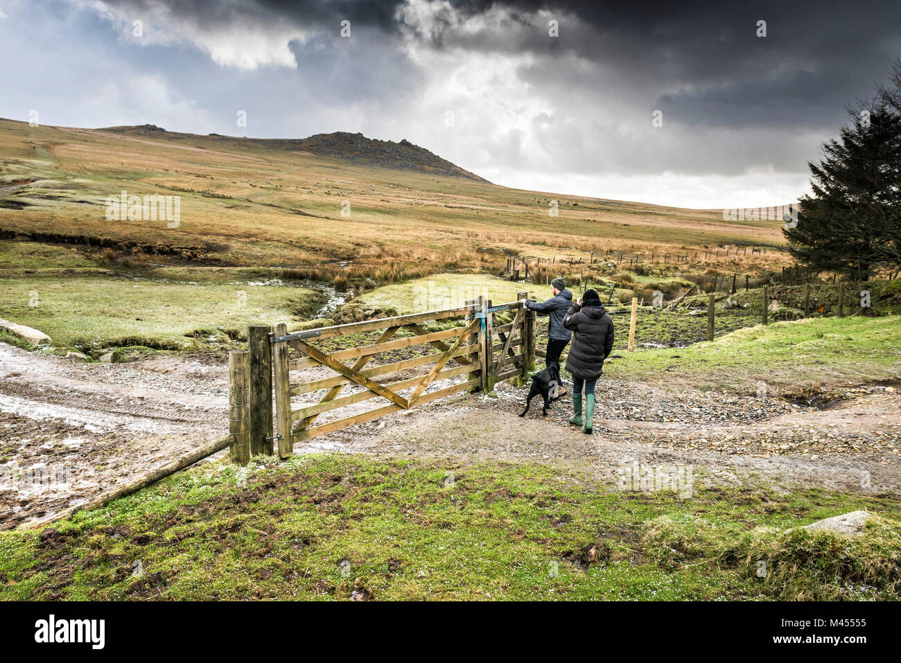 Les marcheurs passe à travers une barrière en bois sur une piste sur Rough Tor sur Bodmin Moor en Cornouailles. Banque D'Images