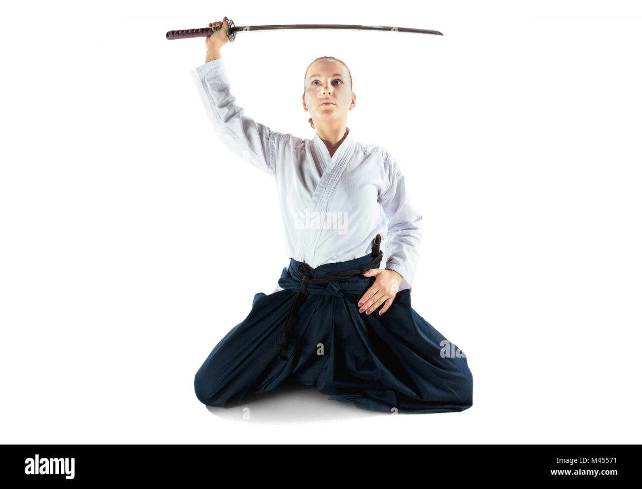 Maître d'Aikido la posture de défense des pratiques. Style de vie sain et de sport concept. Femme en kimono blanc sur fond blanc. Banque D'Images