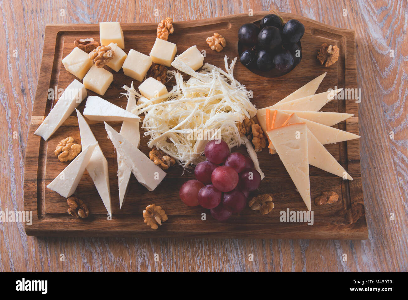 Assortiment de fromages avec les raisins et les noix sur d'un administrateur Banque D'Images