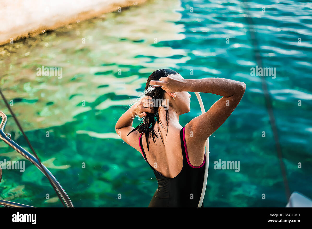 Jeune femme en costume de bain La douche à bord de yacht, Croatie Banque D'Images