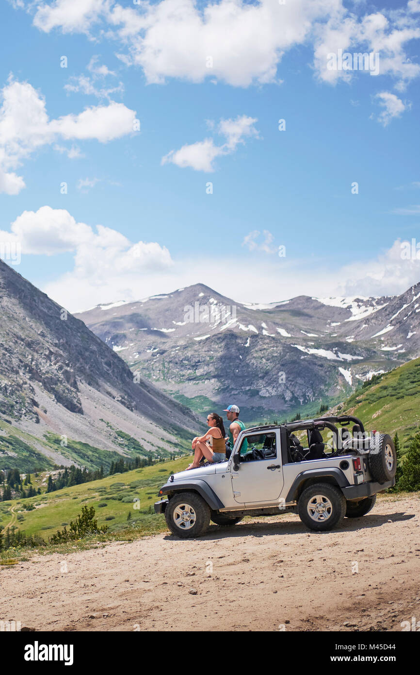Couple de voyage routier en voyant les montagnes depuis le capot du véhicule hors route, Breckenridge, Colorado, USA Banque D'Images