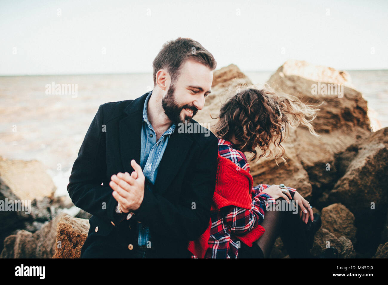 Romantic couple dos à dos sur la plage, Odessa, Ukraine Banque D'Images