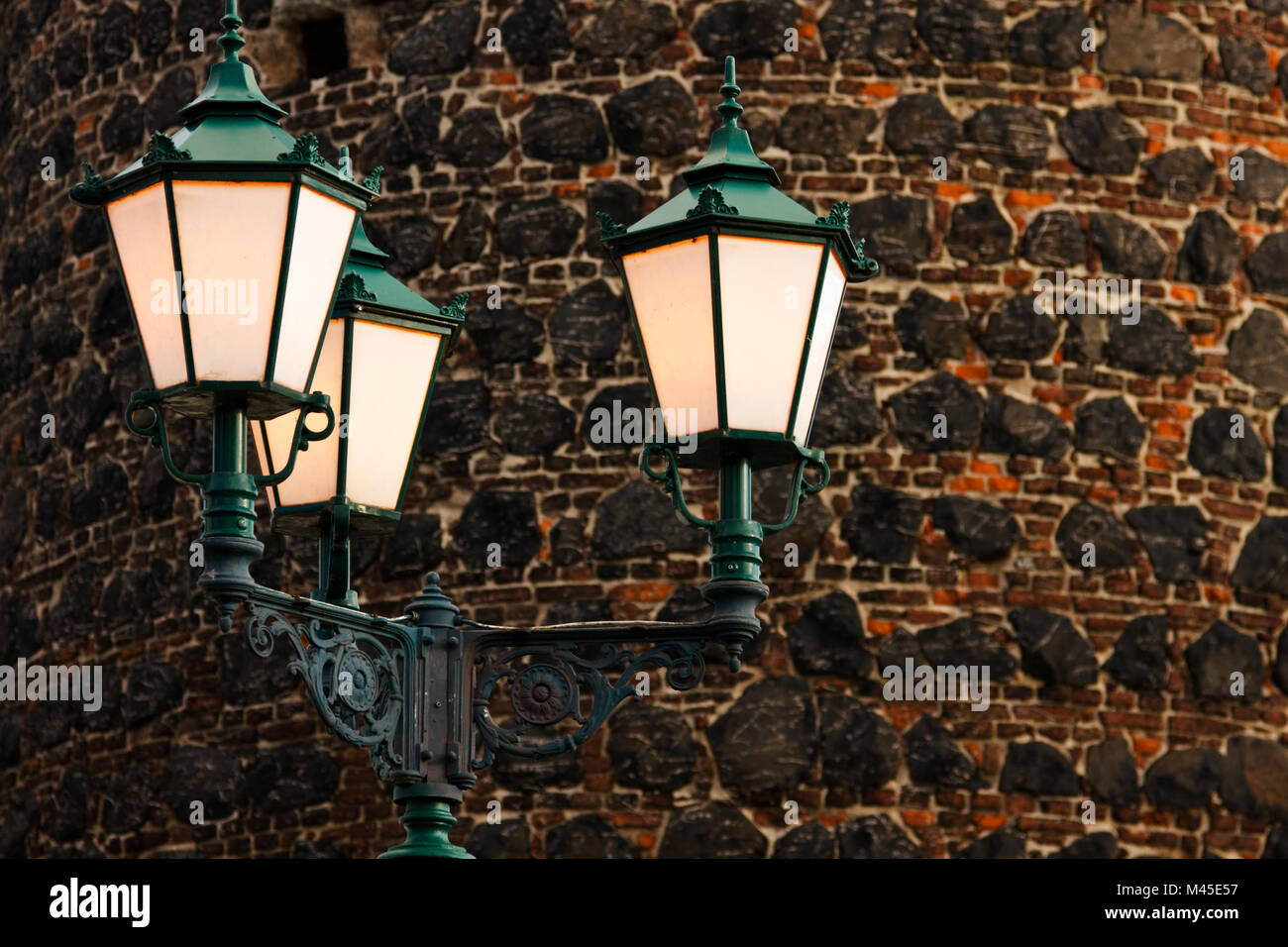 Une rue de la lumière avec la conception médiévale en face d'un vieux mur. Banque D'Images