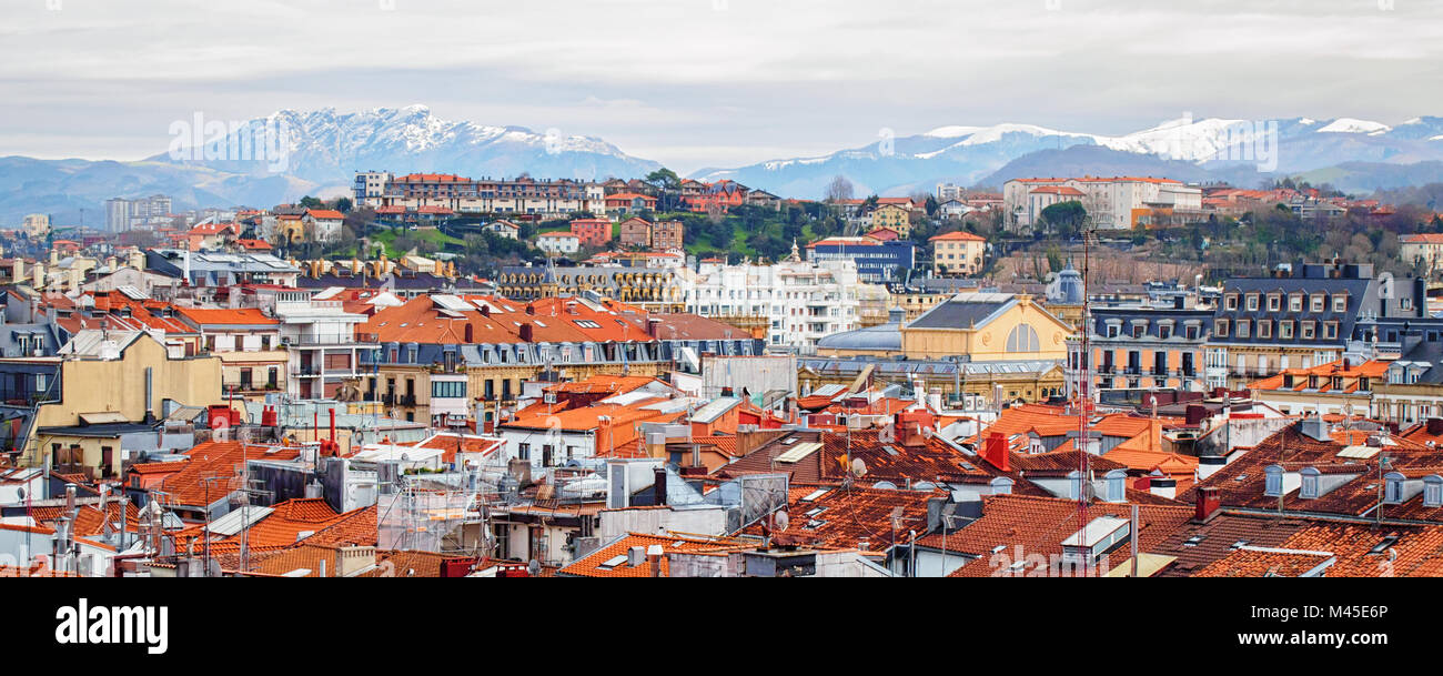 Panorama de San Sebastian (Donostia) en journée d'hiver nuageux avec les montagnes enneigées à l'horizon. Banque D'Images