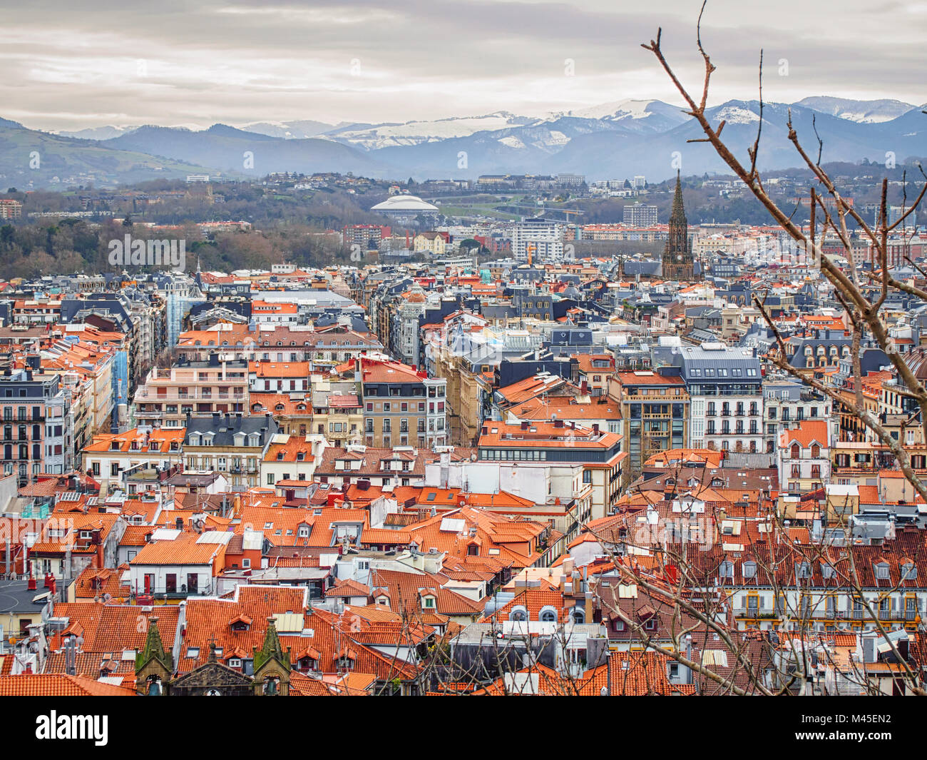 Panorama de San Sebastian (Donostia) en journée d'hiver nuageux avec les montagnes enneigées à l'horizon. Banque D'Images