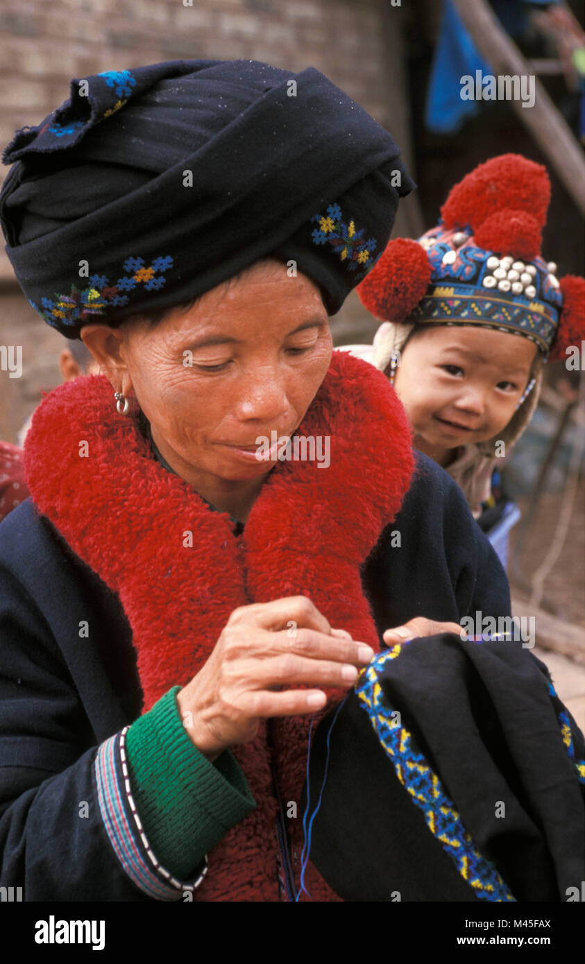Le Laos. Luang Namtha (près de Muang Sing). La tribu Yao Mien (tribu). Vêtements Femme broderie propre. Bébé curieux. Portrait. Banque D'Images