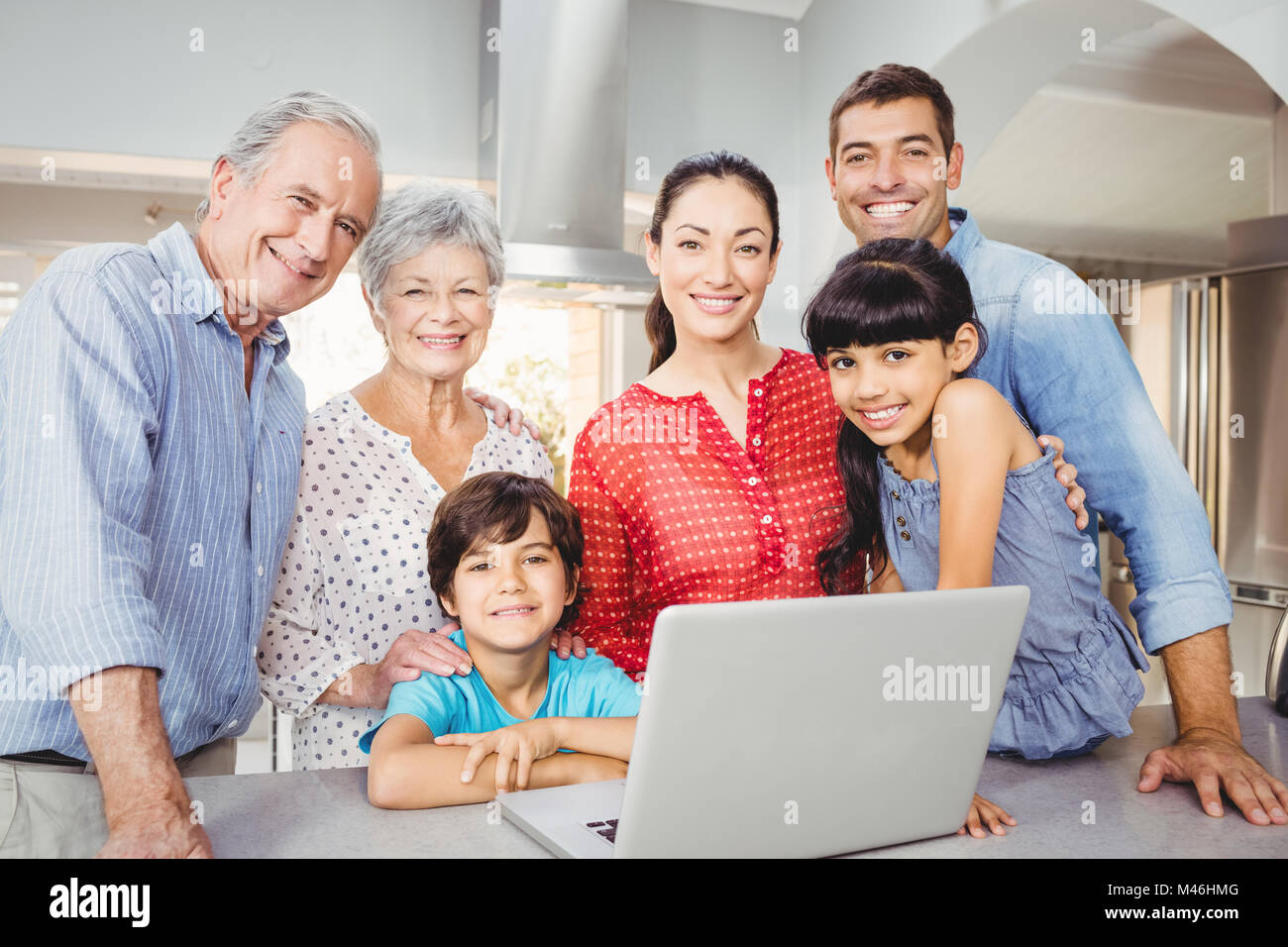 Portrait de famille heureuse avec laptop at home Banque D'Images