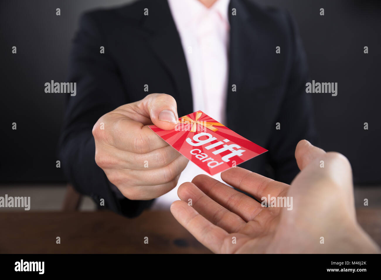 Close-up de l'homme d'affaires mains donnant carte-cadeau pour d'autres affaires Banque D'Images