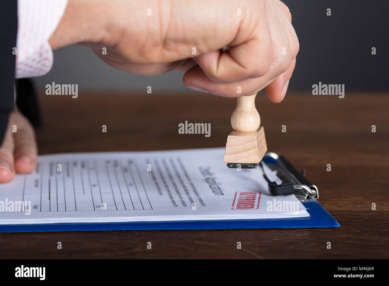 Close-up of a person's Hand piétinement sur le formulaire de demande Approuvé Banque D'Images