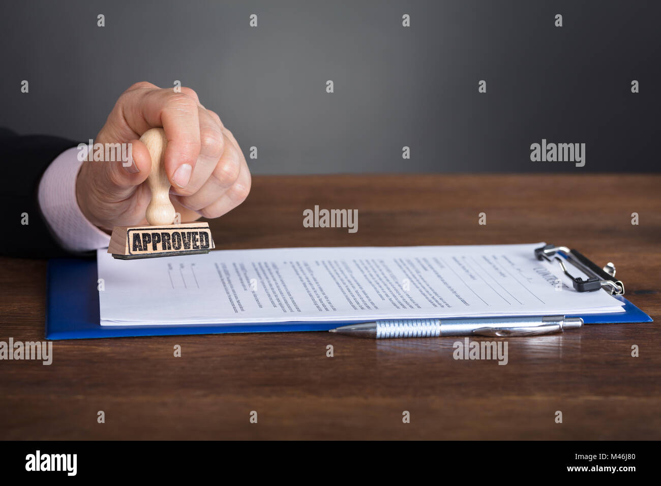 Close-up of a person's Hand piétinement sur le contrat approuvé Banque D'Images