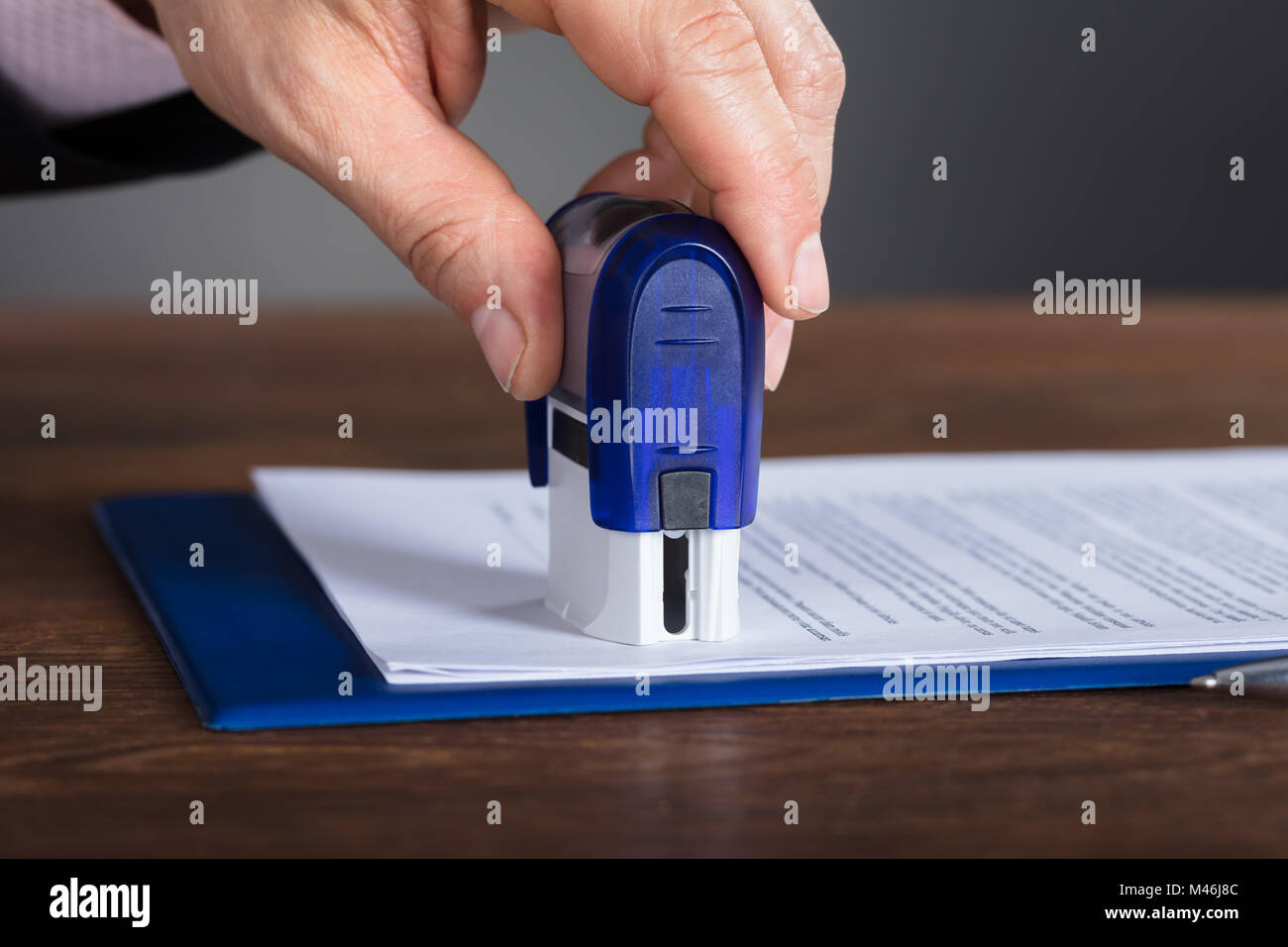 Close-up of a person's Hand Stamping Document sur un bureau en bois Banque D'Images