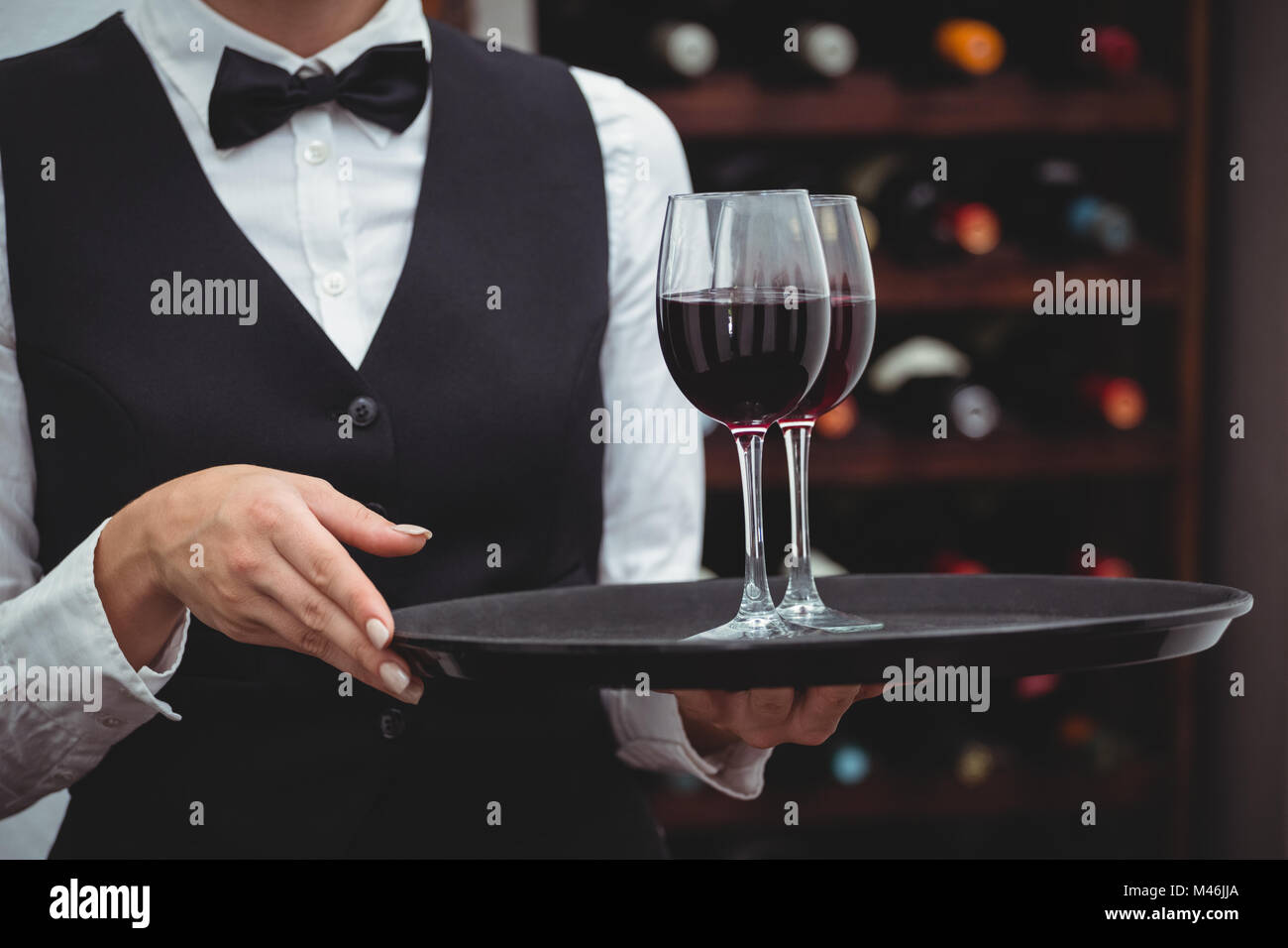 Waitress holding un plateau avec des verres de vin rouge Banque D'Images