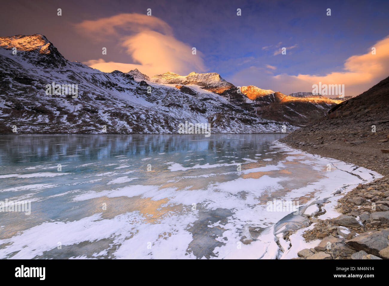 Superbe lever de soleil sur le lac gelé Bianco(Lac Blanc), Col de la Bernina, Engadine, Grisons, Suisse. Banque D'Images