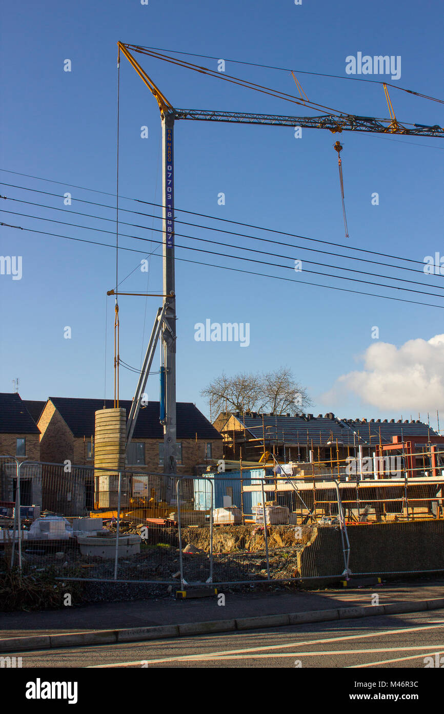 Une seule colonne de grue à tour de style cantilever en usage pour la construction de logements privés occupés à bâtir sur un site dans Bangor comté de Down en Irlande du Nord Banque D'Images