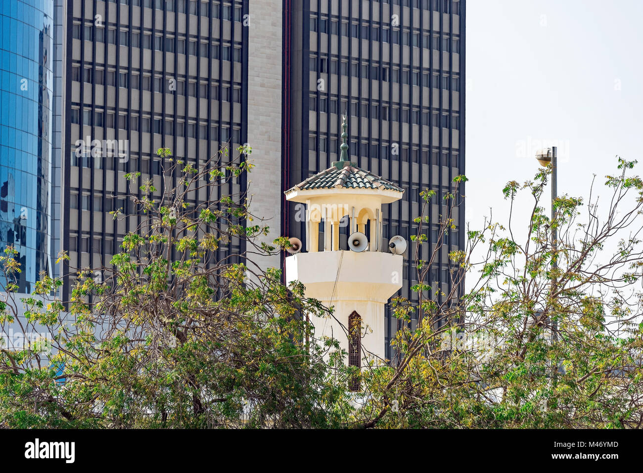 Un appel à la prière. La tour de la mosquée en contraste avec les immeubles de bureaux modernes, Jeddah, Arabie saoudite. Banque D'Images