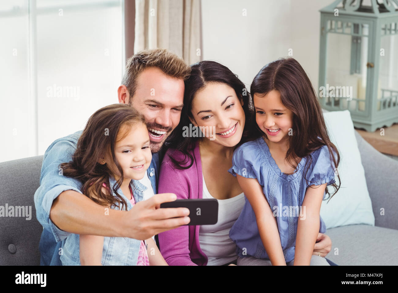 Family smiling tout en tenant le téléphone mobile selfies Banque D'Images