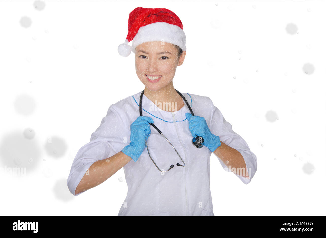 Smiling asian médecin et Santa hat with snow Banque D'Images