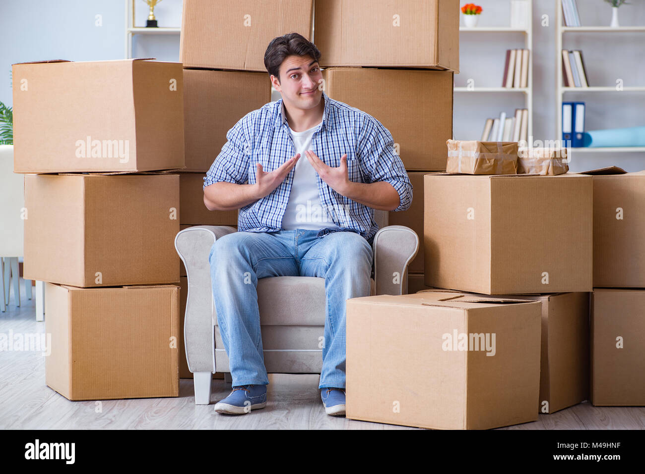 Jeune homme déménagement dans de nouvelles boîtes avec chambre Banque D'Images