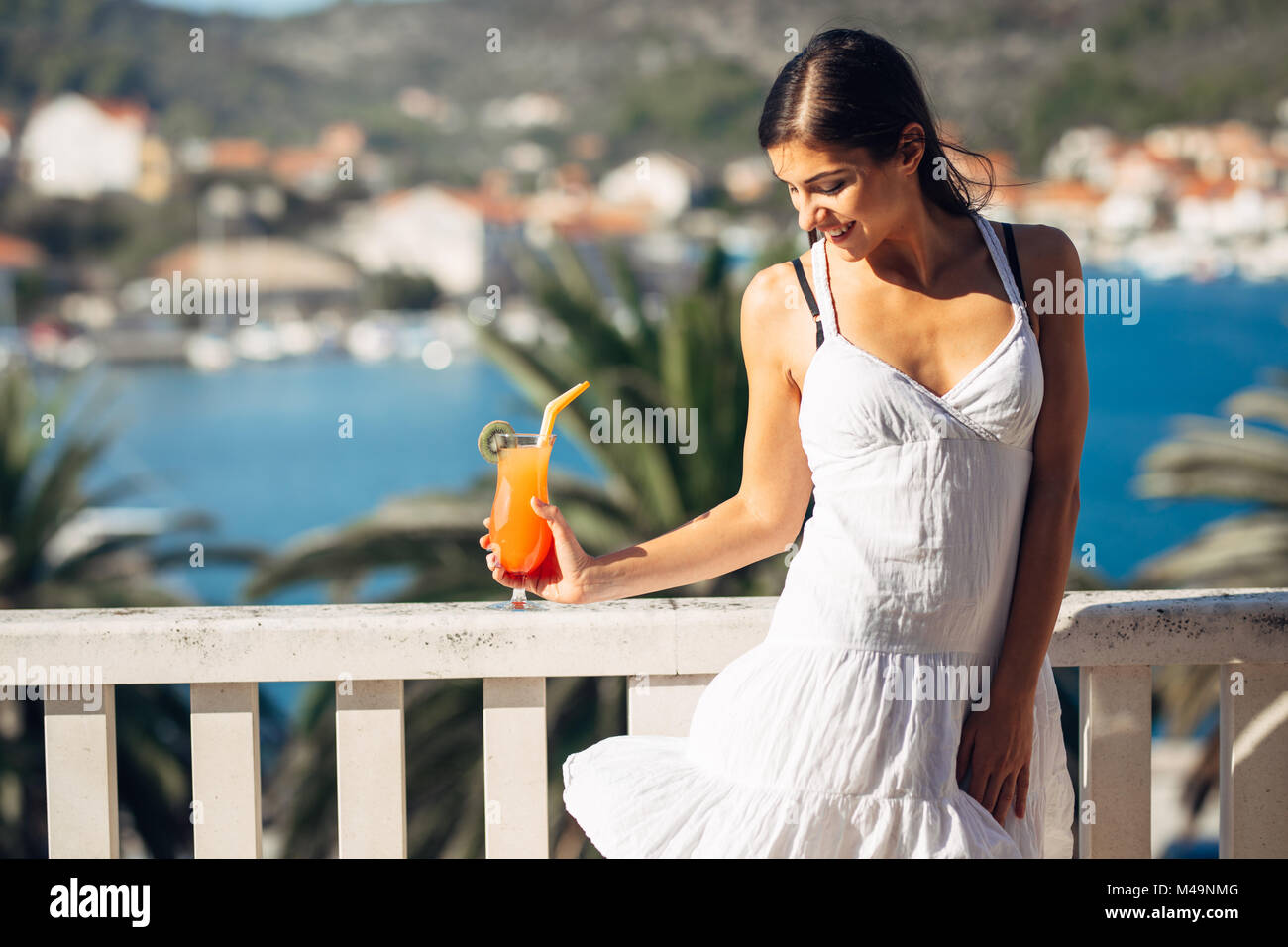 Les jeunes femmes bénéficiant d''un cocktail coloré sur la vue panoramique terrasse de l'hôtel.délicieux smoothie cocktail froid pour l'été il fait chaud. Banque D'Images