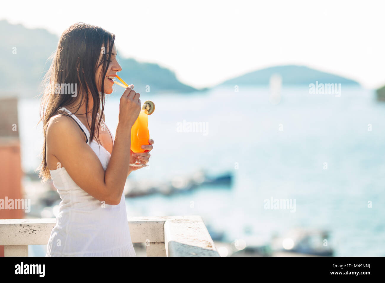 Les jeunes femmes bénéficiant d''un cocktail coloré sur la vue panoramique terrasse de l'hôtel.délicieux smoothie cocktail froid pour l'été il fait chaud. Banque D'Images