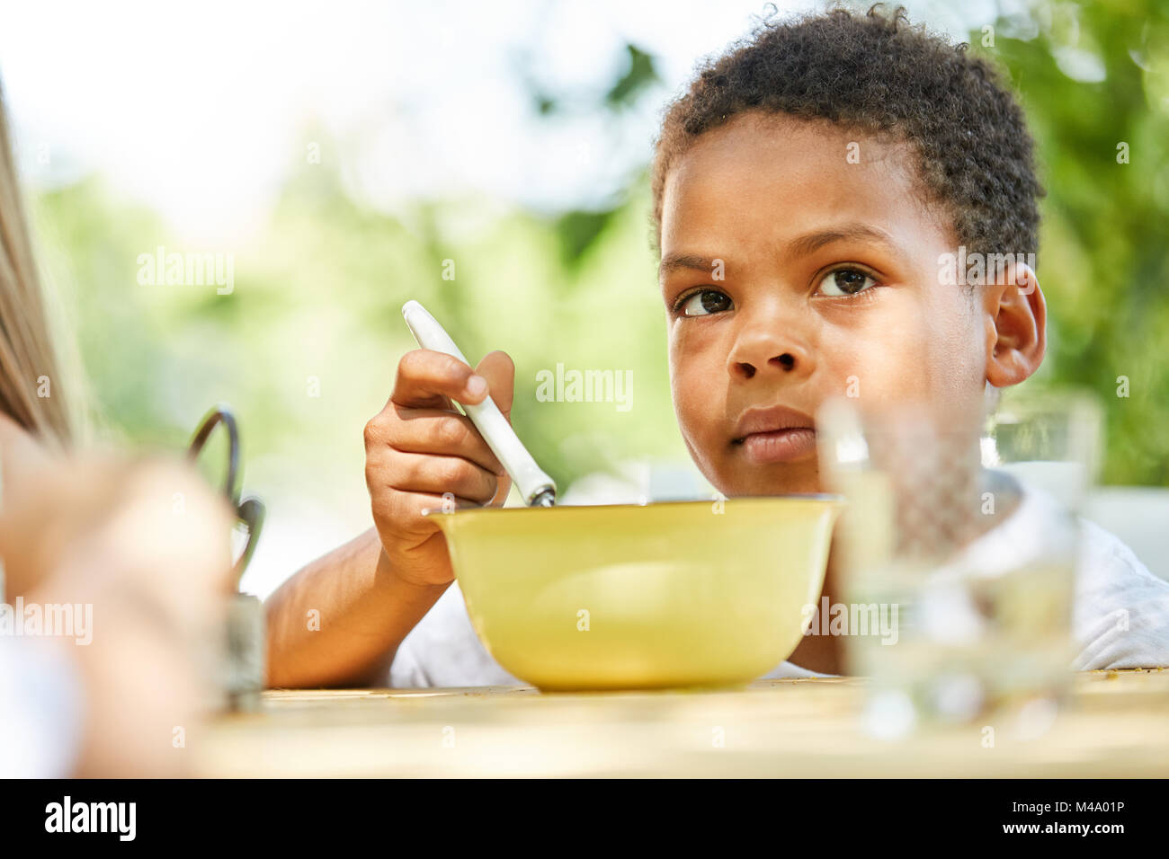 African boy est manger sain céréale en camp de vacances international Banque D'Images